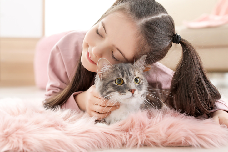 menina carinhosa encostada a gato